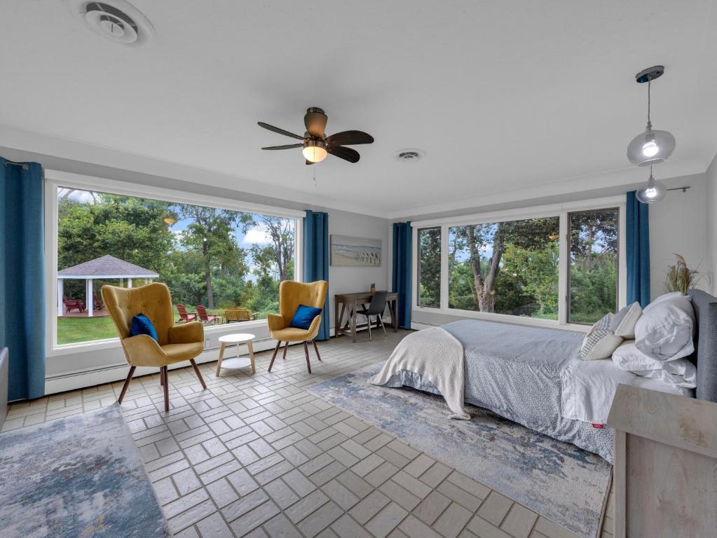 利明顿Coastal Suite - Seacliff Beach Suites的一间卧室配有一张床、椅子和窗户。