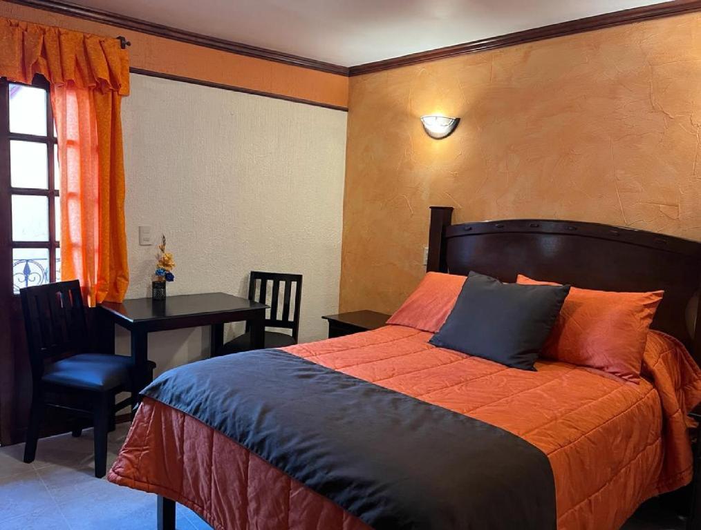 米内拉尔德尔蒙特Hotel Paraiso Real Plus的一间卧室配有一张床、一张桌子和一张书桌