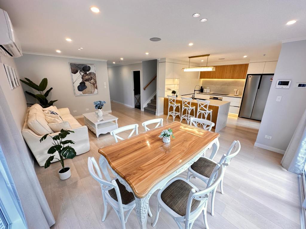 奥克兰123B Forresthill Rd的厨房以及带木桌和椅子的客厅。