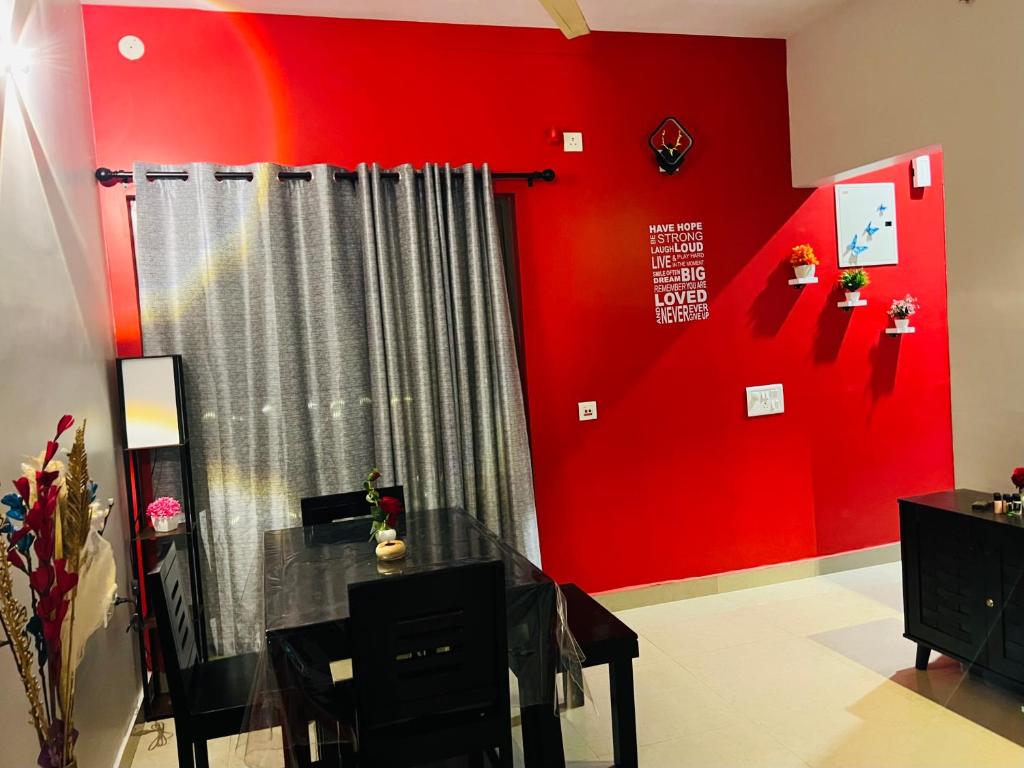 BāruipurTani s Homestay的一间红色墙壁和窗帘的房间