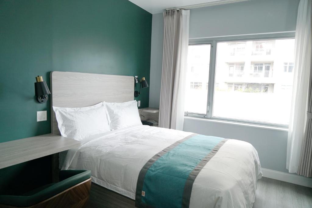 法拉盛Starlight Hotel的一间卧室设有一张大床和一个窗户。