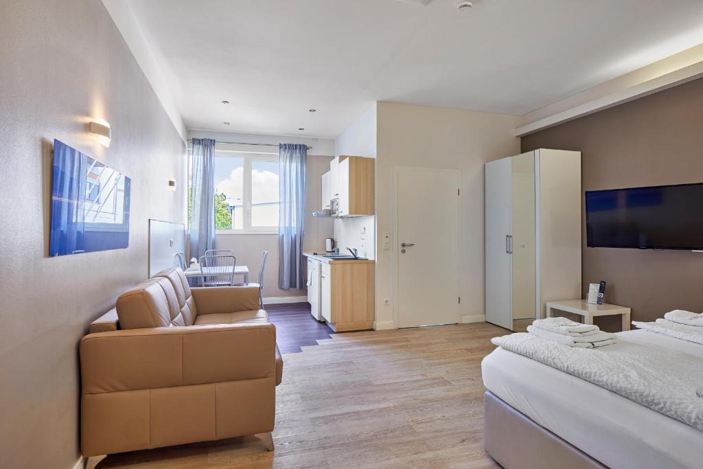 海德堡伯丁海德堡酒店的一间卧室配有一张床和一张沙发,还设有一间厨房