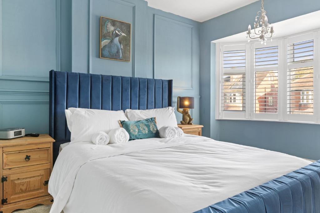 拉夫堡Lovely 2 Bedroom House with Parking的蓝色卧室配有一张带白色床单的大床