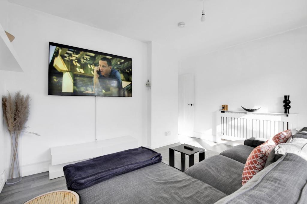 伦敦Peckham apartments by APS的客厅配有沙发和墙上的电视