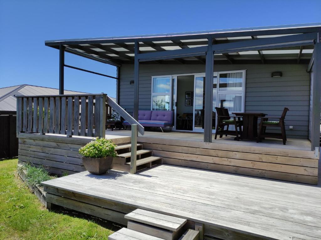 图朗伊Modern House near Motuoapa Tongariro Crossing fishing skiing的房屋设有木甲板和桌子