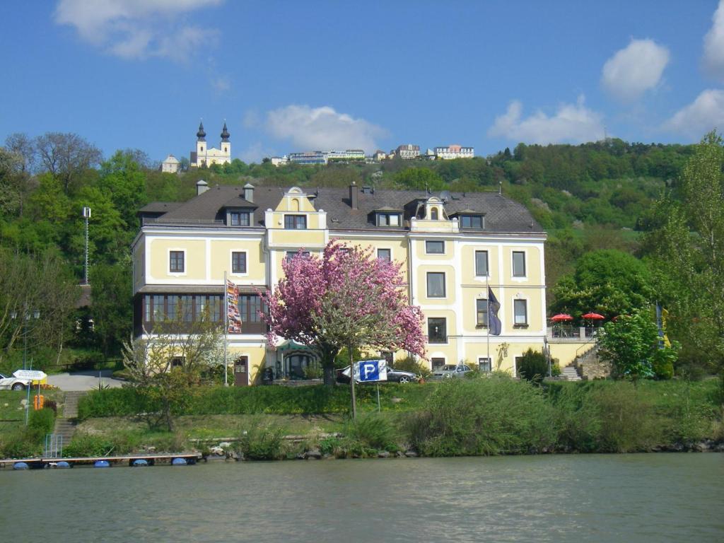 多瑙河畔的马尔巴赫Donau-Rad-Hotel Wachauerhof的河边小山上的白色大房子