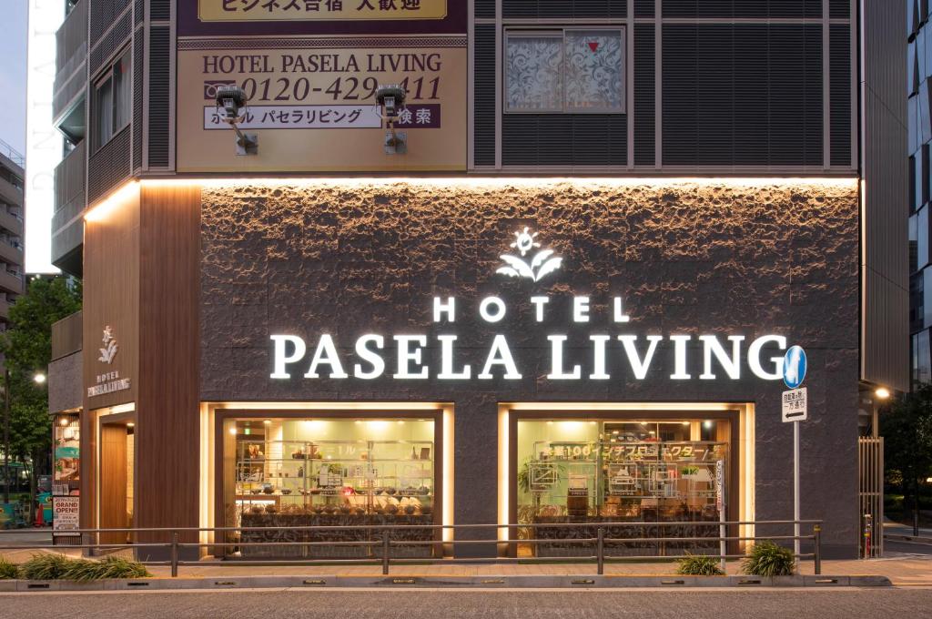 东京Hotel Pasela Living的建筑一侧的酒店Pasella生活标志