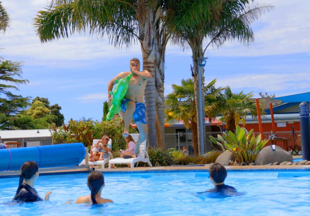 纳皮尔纳皮尔肯尼迪公园度假酒店的游泳池里的人,有冲浪板