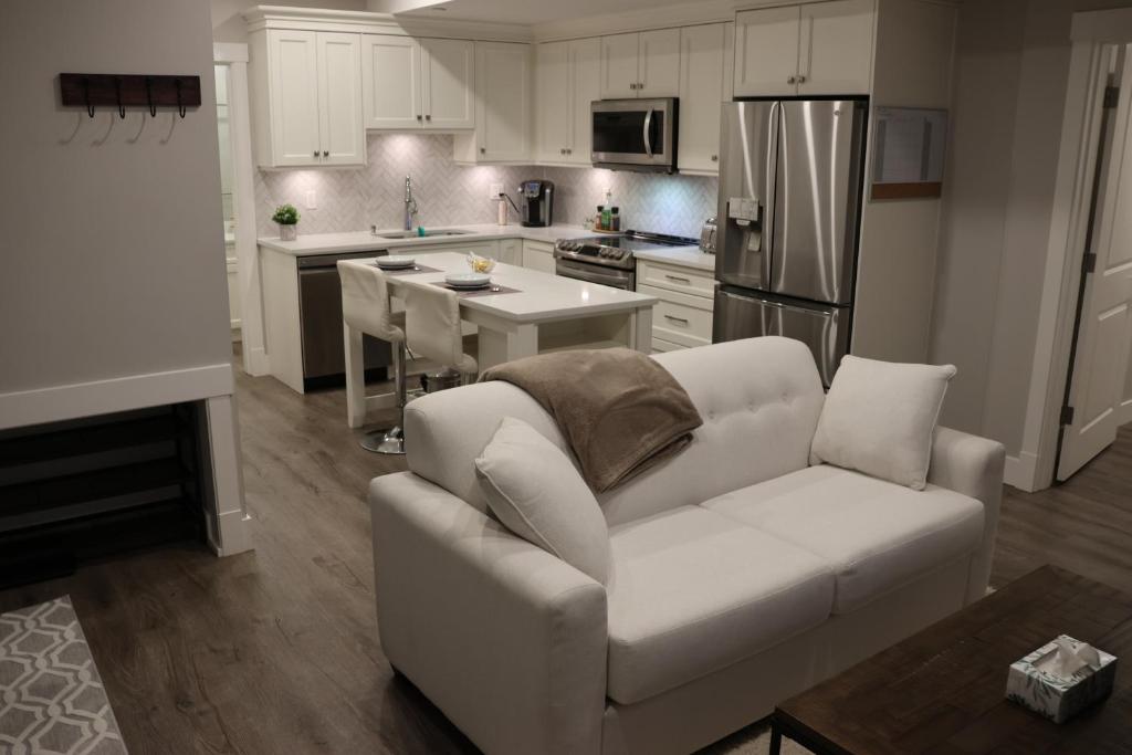 枫树岭Golden Ears Nature's Delight的一间带白色沙发的客厅和一间厨房