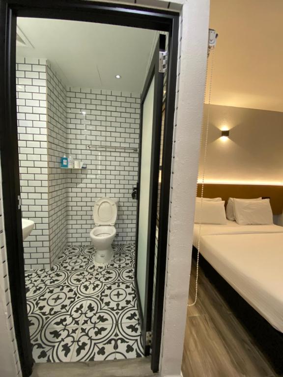 乔治市Georgetown Inn by Sky Hive的一间带卫生间的浴室和一张位于客房内的床。