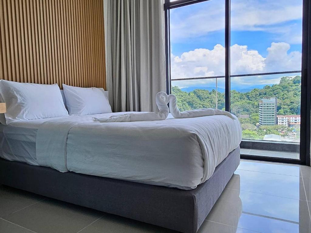 哥打京那巴鲁Cityview Studio Apartment at Kota Kinabalu City Centre的一间卧室设有一张大床和大窗户