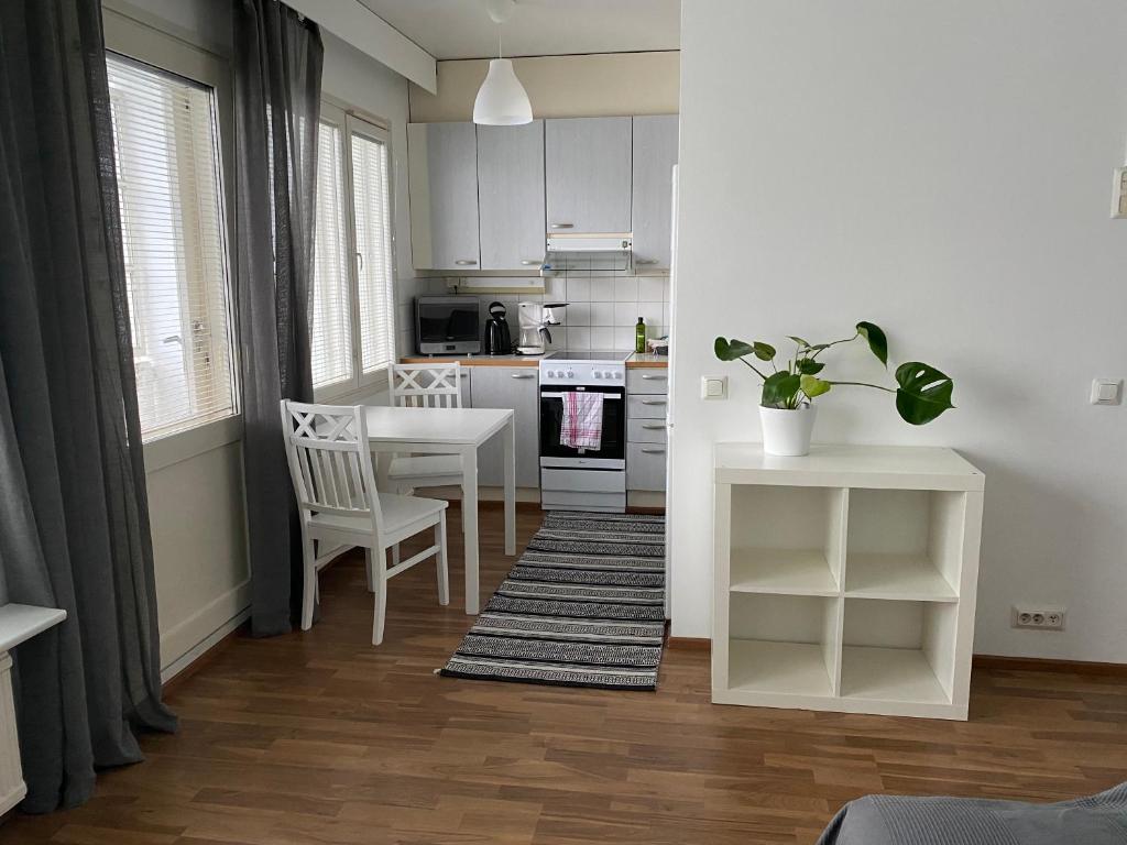 约恩苏Tilava yksiö Niinivaaralla的厨房配有白色橱柜和桌椅