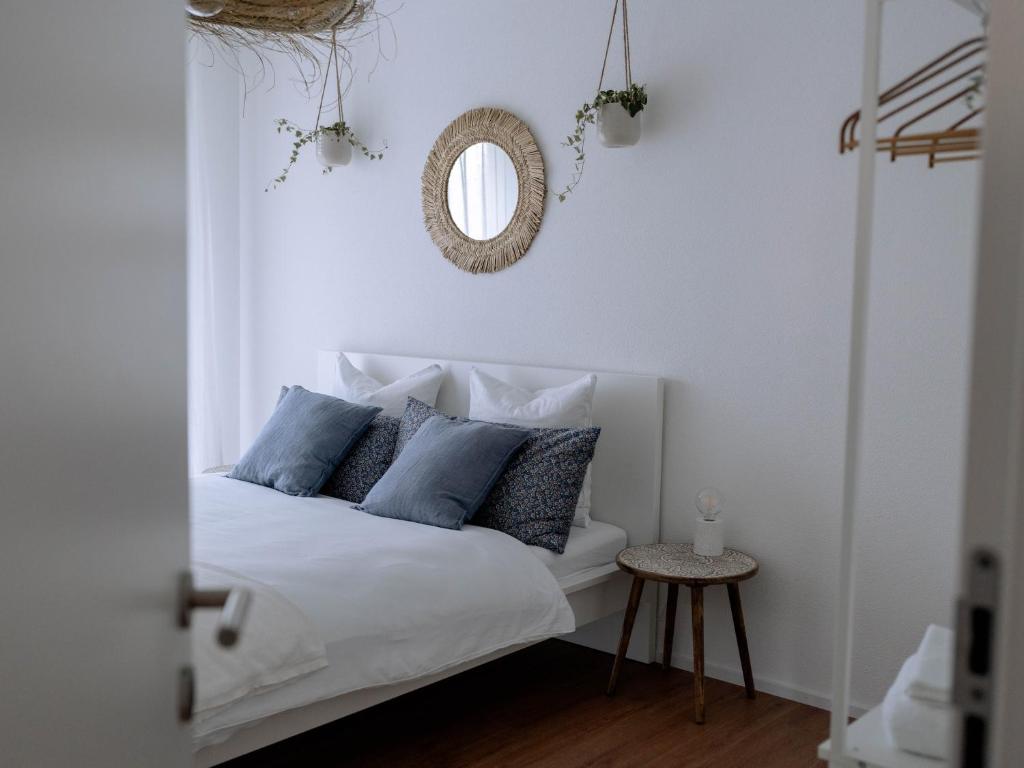 贝肯里德Chez-Marie Vue fantastique entre lac et montagne的一间卧室配有一张带蓝色枕头和镜子的床