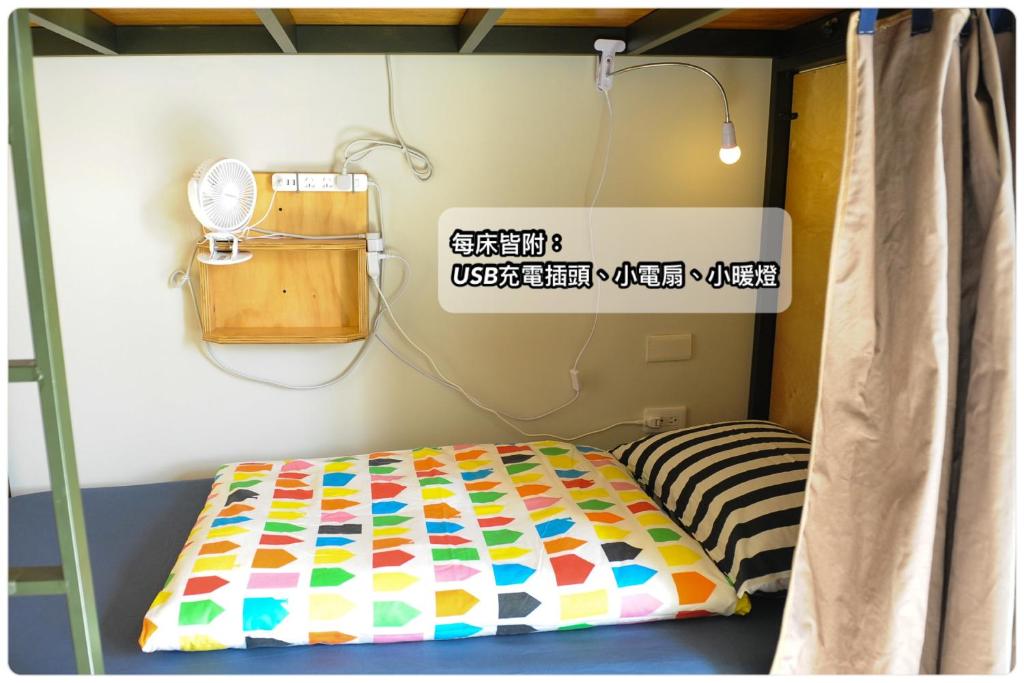 台东台东ohana的天空青年旅馆的一间有标志的房间,配有一张床