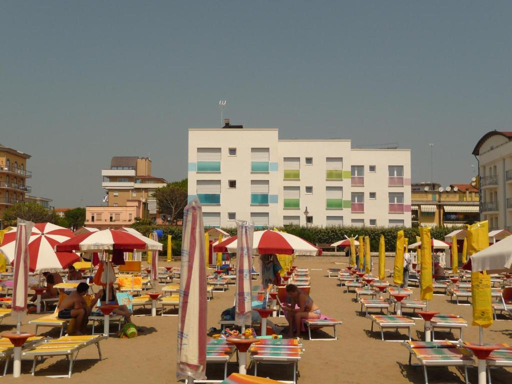 卡奥莱Soggiorno Aurora的海滩上有许多椅子和遮阳伞,还有一座建筑