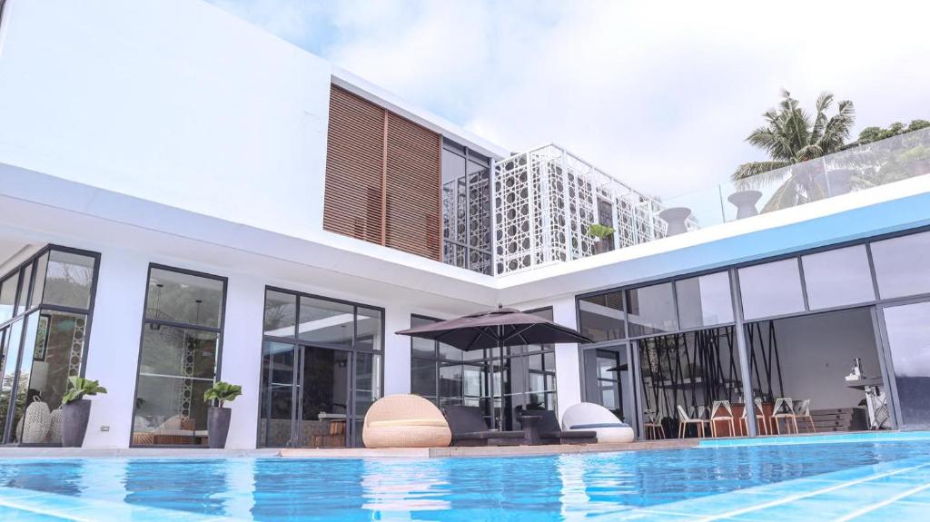 马比尼Sisid Anilao Resort的一座带游泳池和大楼的房子