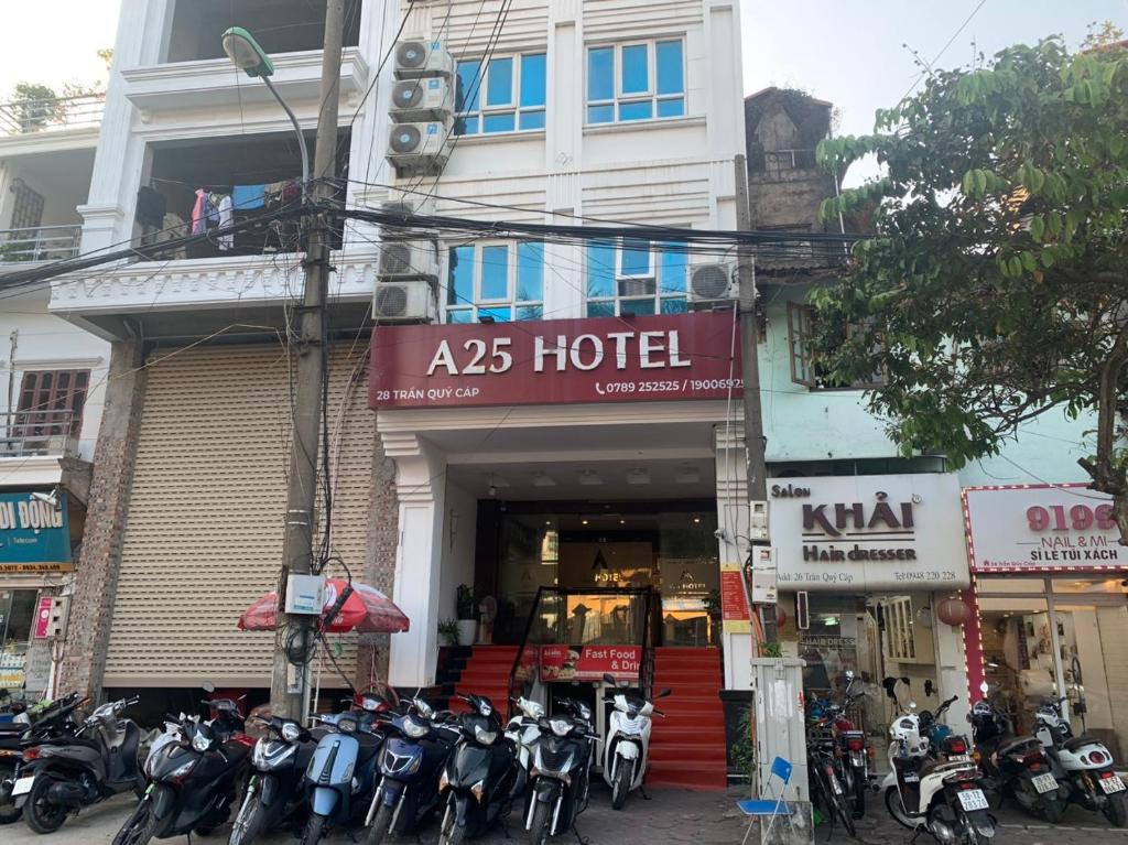 河内A25 Hotel - 28 Trần Quý Cáp的停在酒店前面的一组摩托车