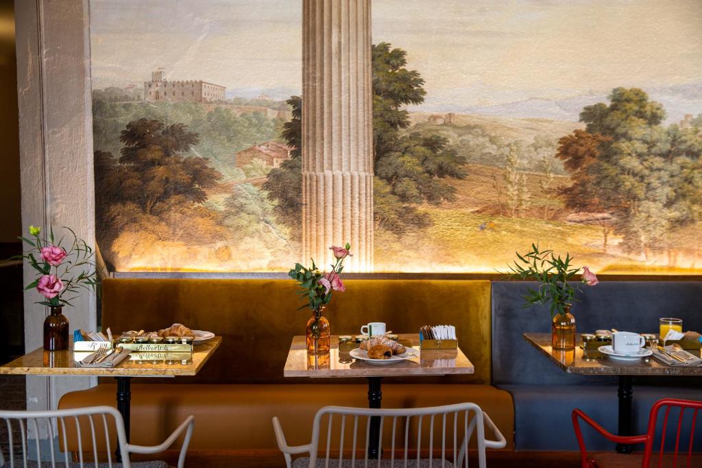 佛罗伦萨Stella d'Italia的餐厅里有两个桌子,墙上挂着一幅画