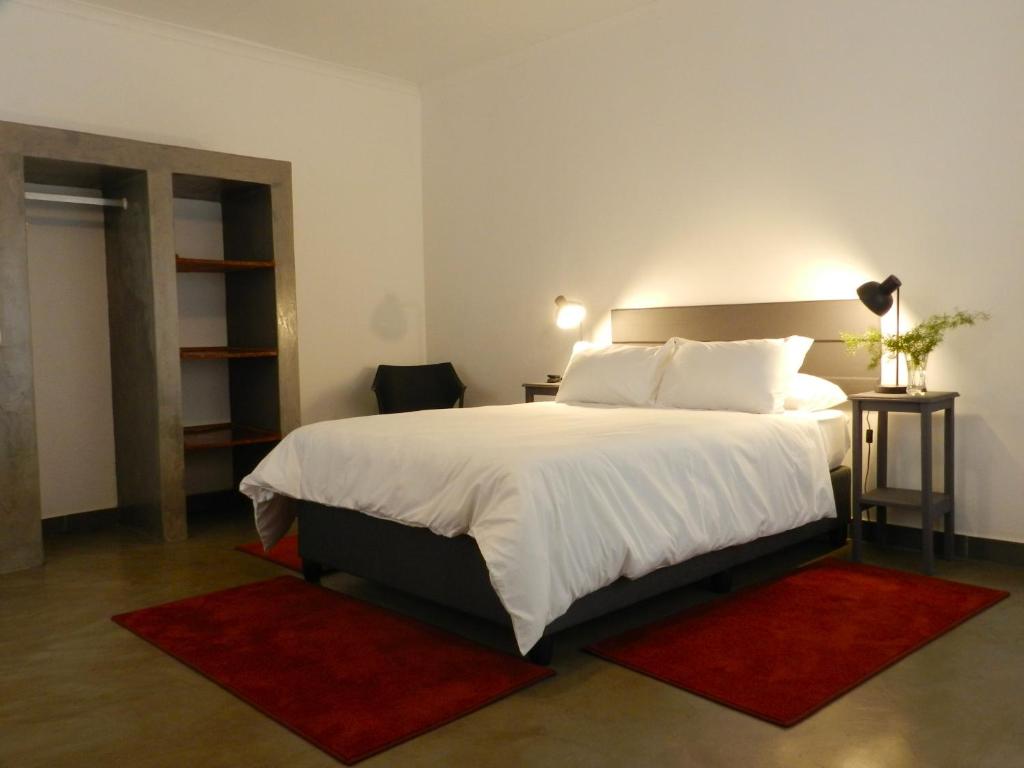 勒斯滕堡President Paul Kruger Guest Lodge的卧室配有一张大白色的红色地毯