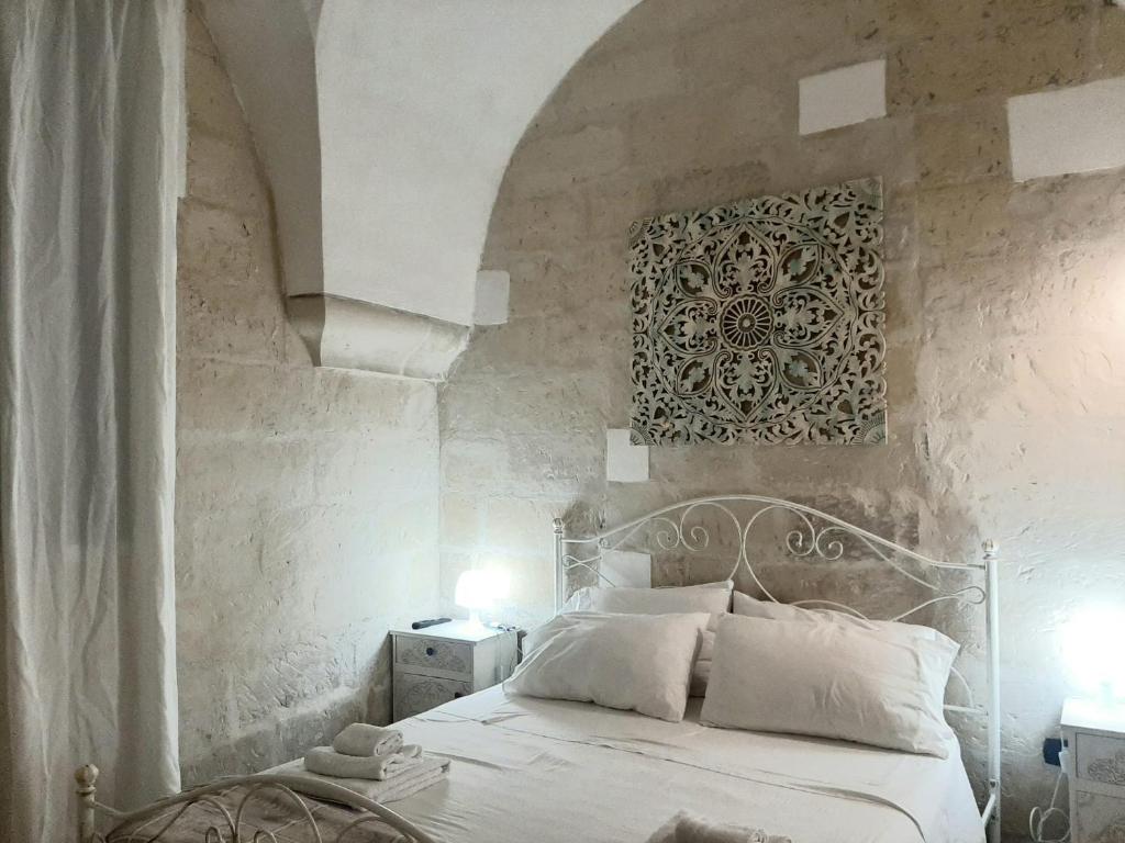 莱切Il Vico的卧室配有白色的床和石墙