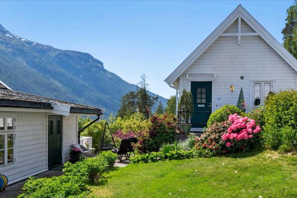 凯于庞厄尔Nydelig lite hus med egen vedfyrt baksteovn.的一座白色的小房子,带鲜花的院子