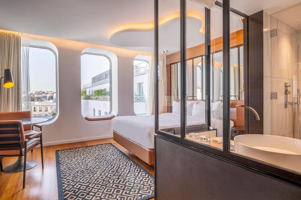 巴黎Renaissance Paris Republique Hotel & Spa的酒店客房配有一张床和浴缸。