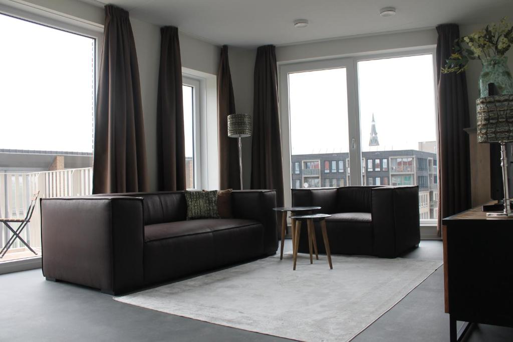 埃因霍温Trompstraat Eindhoven的客厅配有黑色家具和大窗户