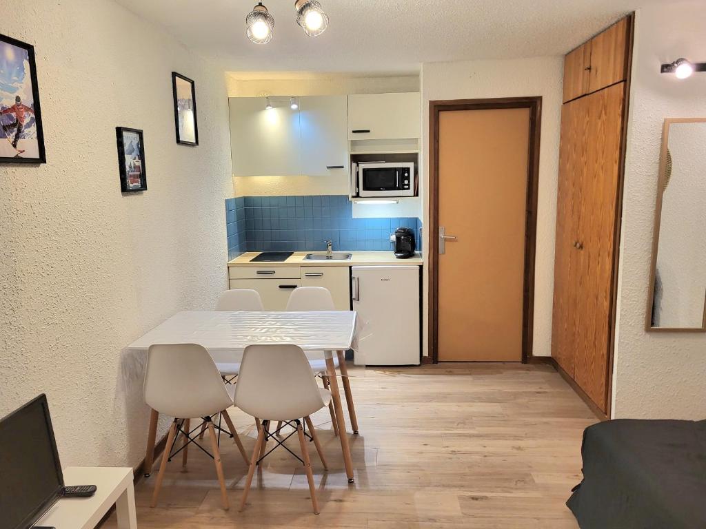 莱索尔Appartement 4pers rénové de 24M2 pied des pistes的厨房以及带桌椅的用餐室。