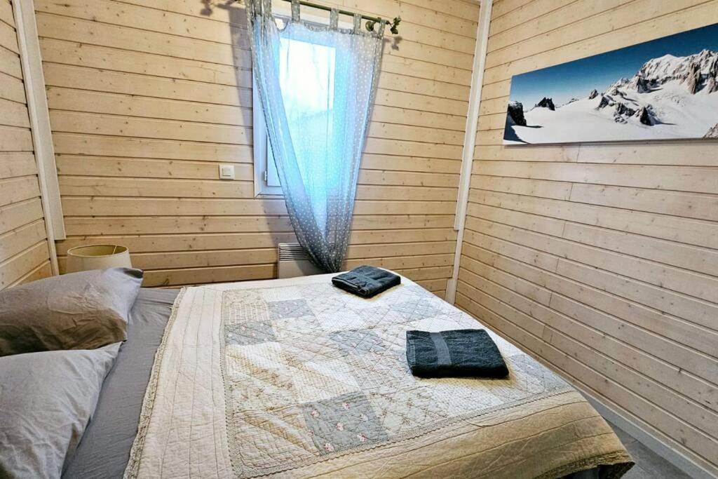 玛根塞尔Le Chalet Du Redon的一间卧室配有一张带窗户和毯子的床