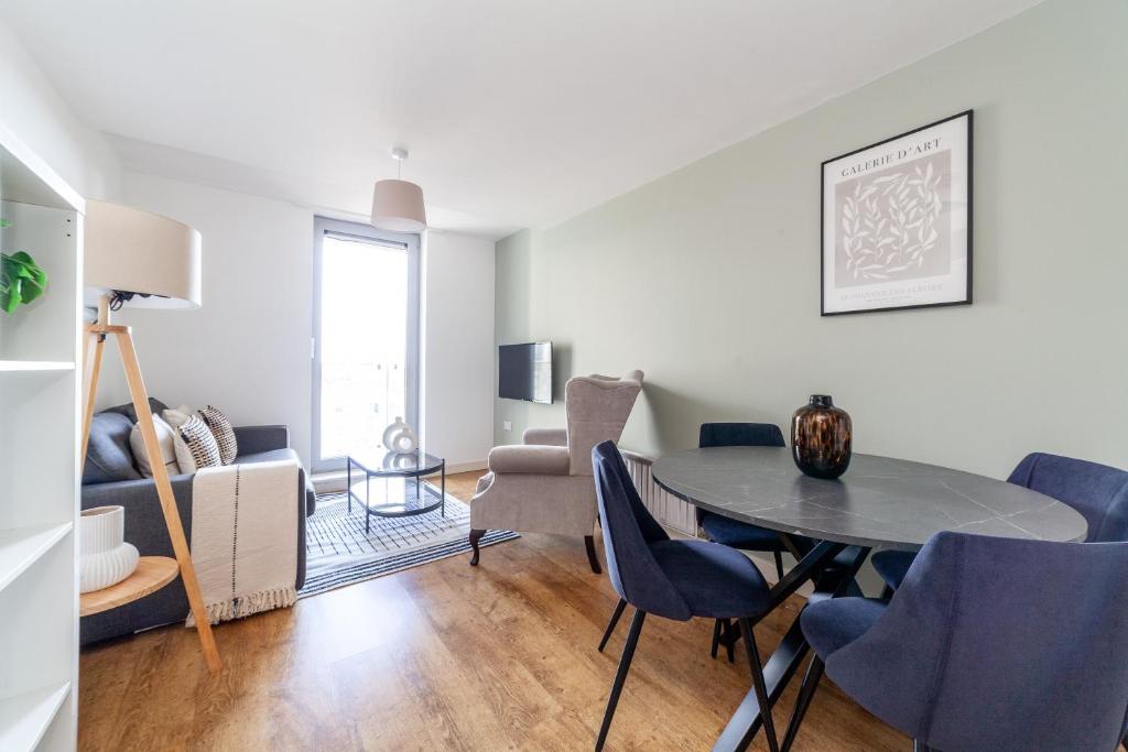 伦敦The Stratford Apartment的客厅配有桌子和蓝色椅子