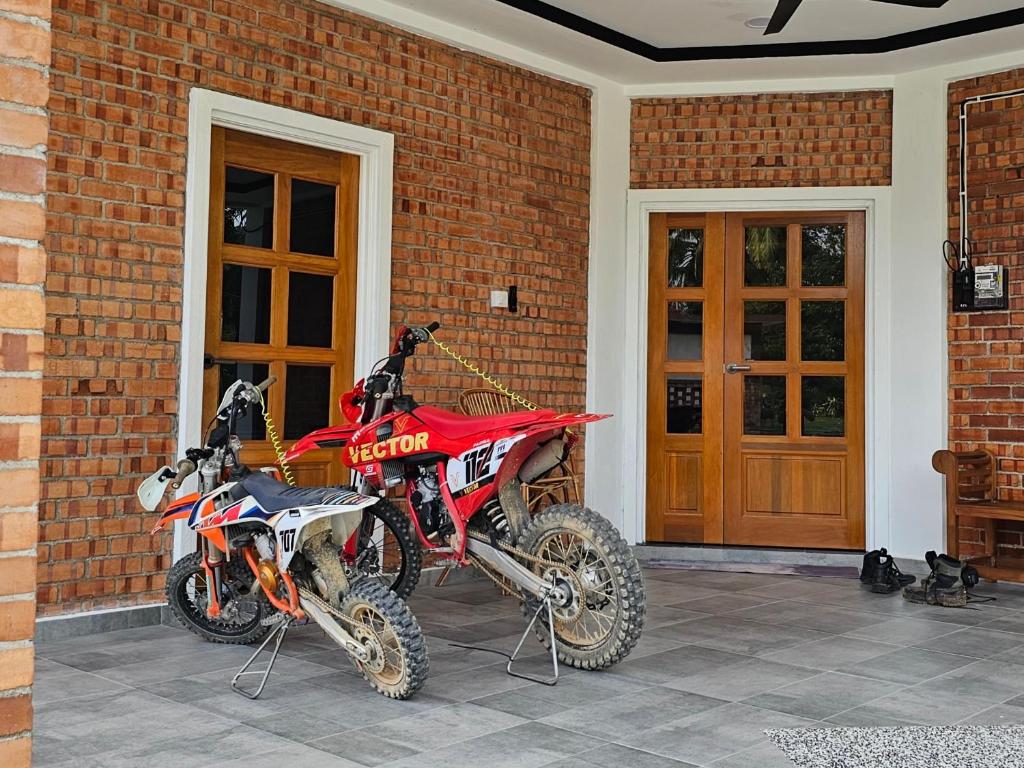 Batang BerjuntaiBRIK 'N BATA的停在砖房旁边的一辆红色的土自行车