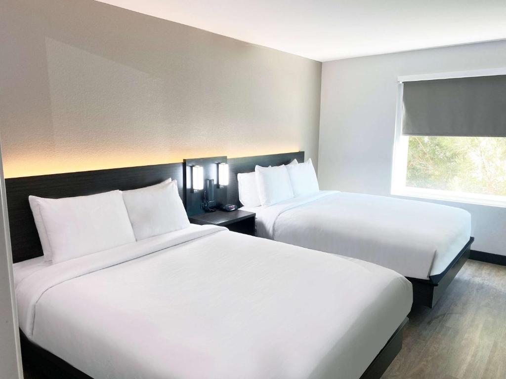 霍布斯Hawthorn Extended Stay by Wyndham Hobbs的酒店客房设有两张床和窗户。