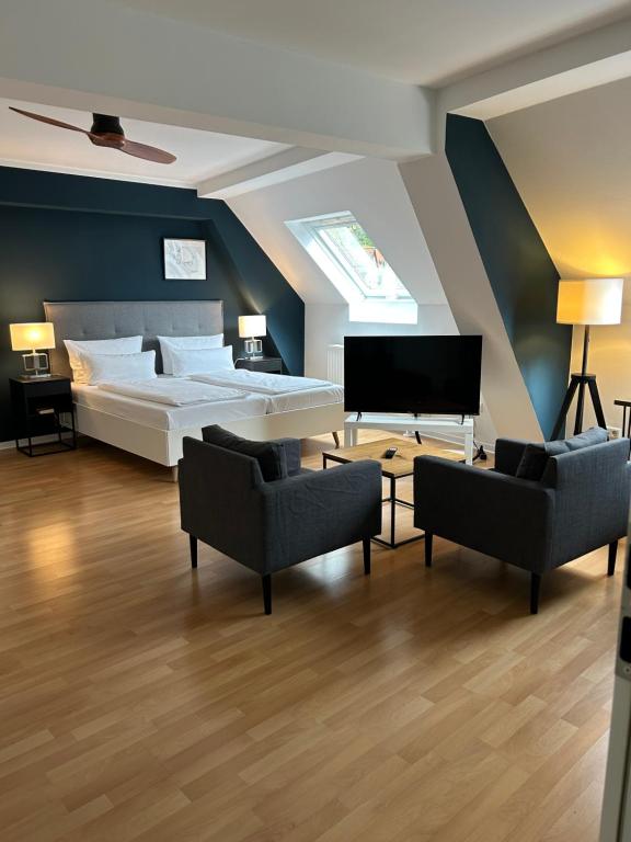 海德堡DK Hotel Deutscher Kaiser的一间卧室配有一张床、两把椅子和一架钢琴