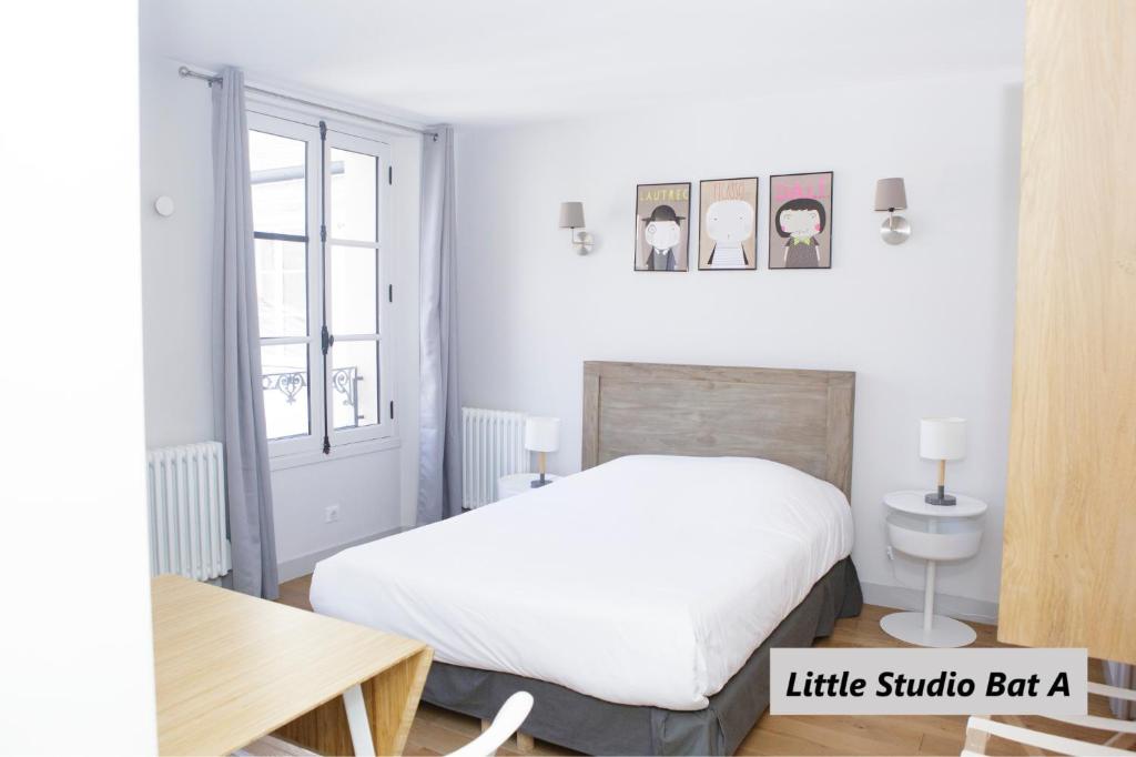 凡尔赛隆科尔路易公寓式酒店的一间小卧室,配有一张床和一张桌子