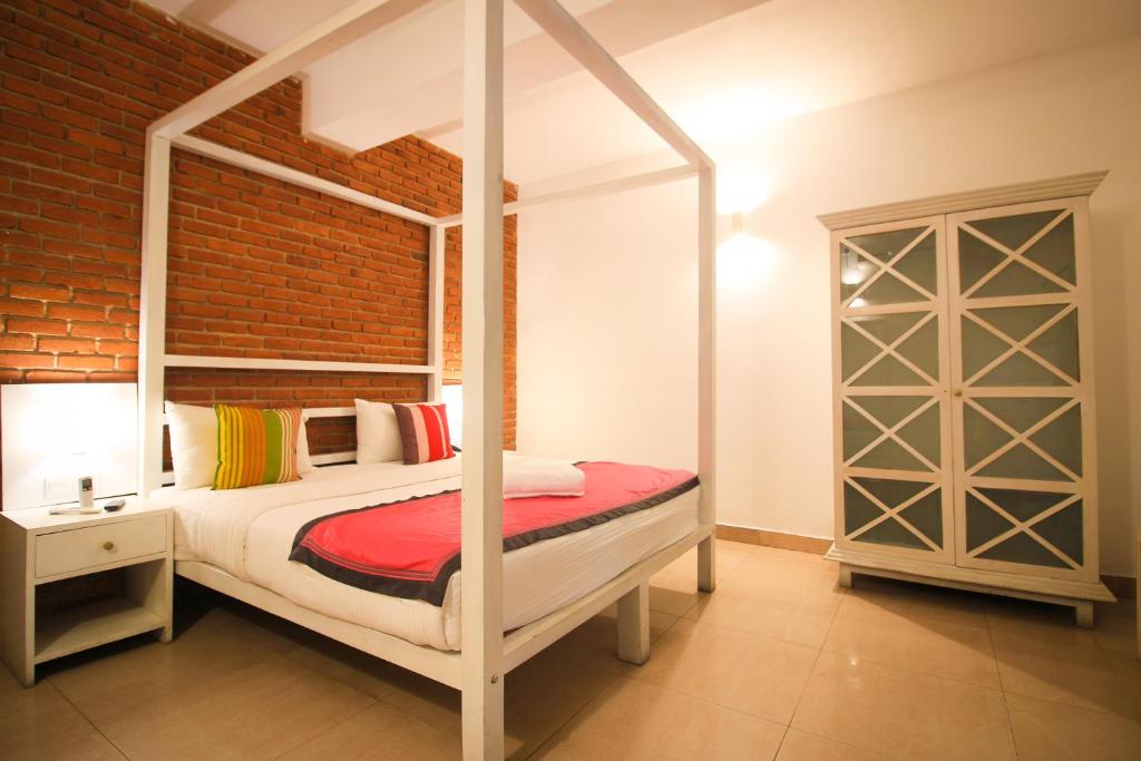 拉维尼亚山代希瓦勒时钟旅舍的一间卧室设有天蓬床和砖墙