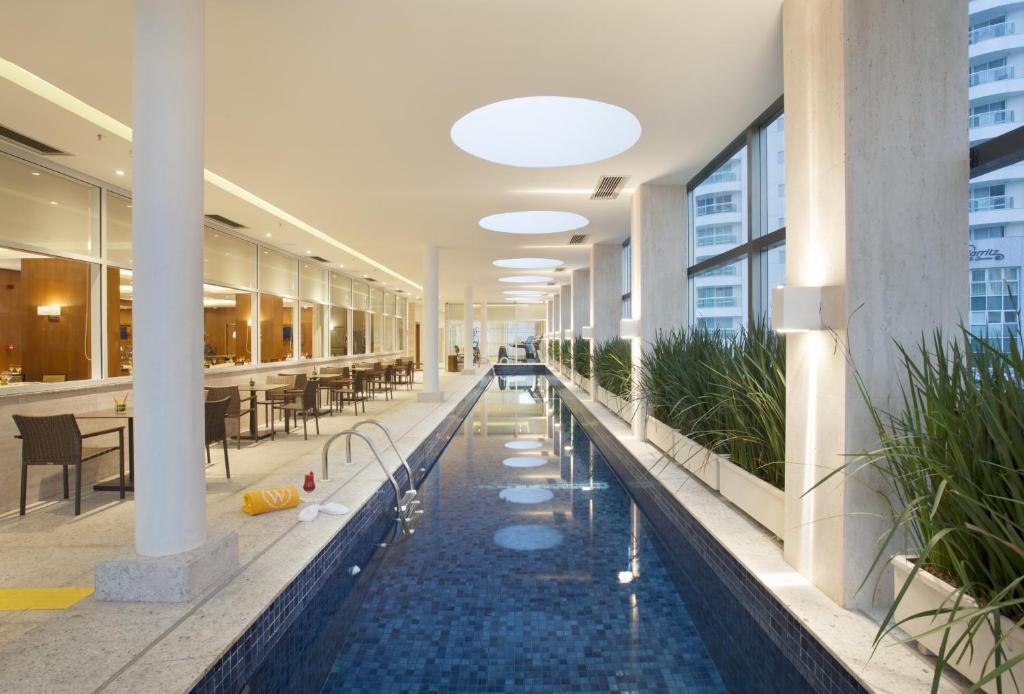 巴西利亚Windsor Brasilia Hotel的一座大建筑,中间设有一个游泳池