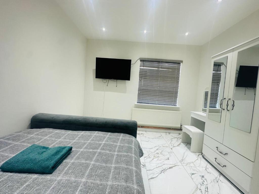 HorninglowKNIGHTSBRIDGE COURT的一间卧室配有一张床和一台平面电视