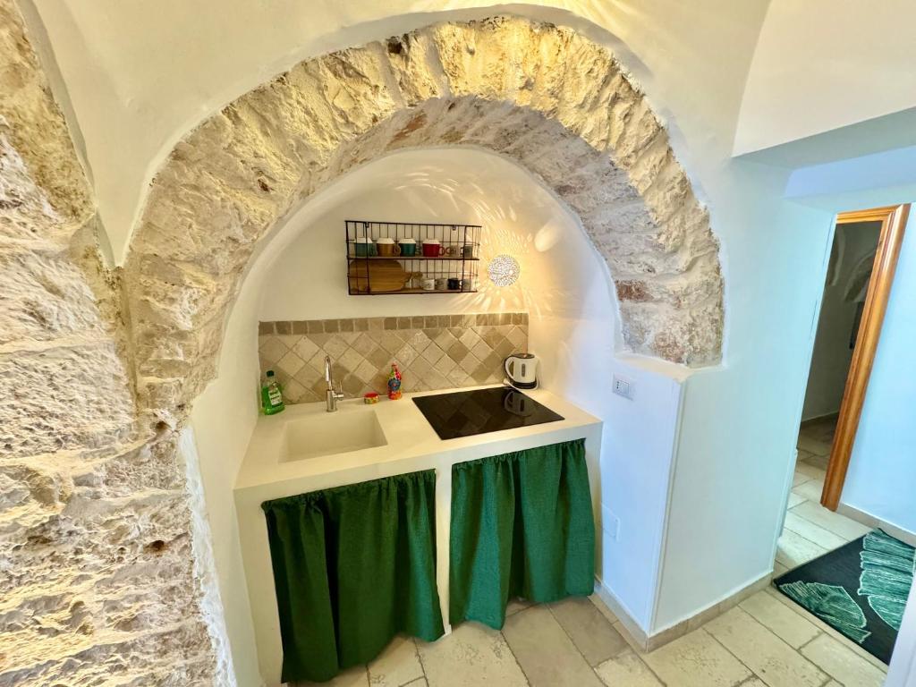 阿尔贝罗贝洛阿尔贝罗贝洛特鲁利芬尼斯度假屋的一个带水槽和石墙的厨房
