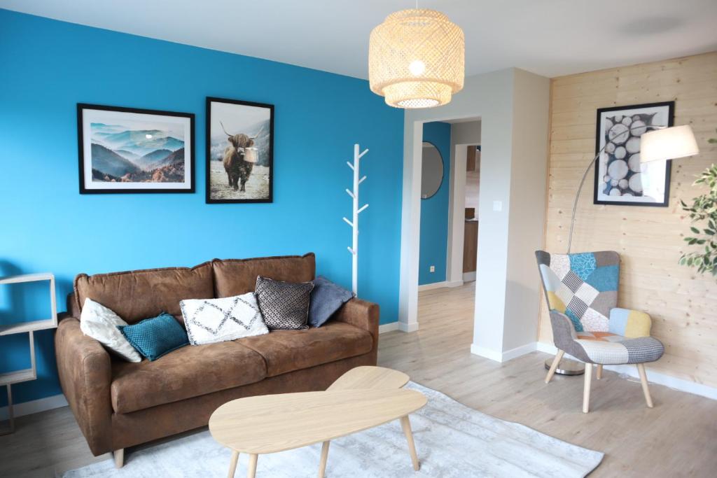 欧丹库尔L'Insoupçonné : garage, proche Axone, Stellantis的客厅设有棕色沙发和蓝色的墙壁