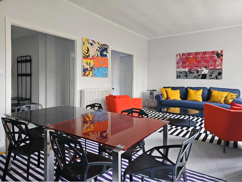 图卢兹L'Idrac, Appartements en Hyper centre的客厅配有玻璃桌和椅子