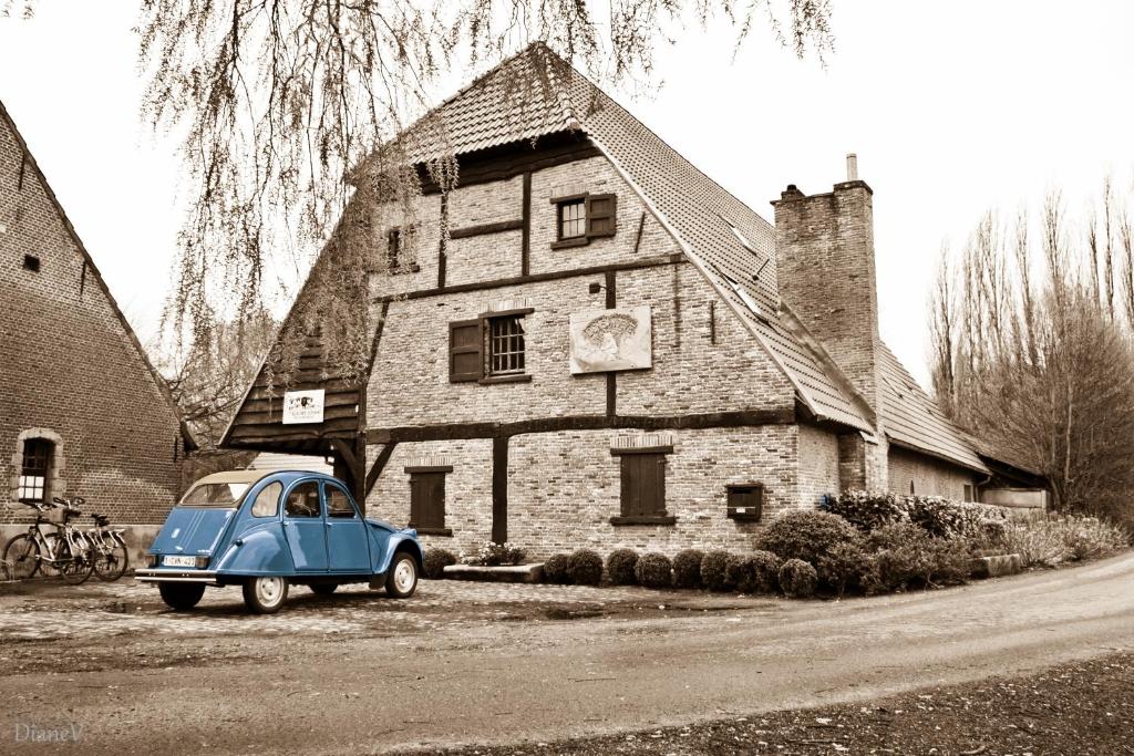 Ranst岩羊住宿加早餐旅馆的停在房子前面的一辆旧蓝色汽车