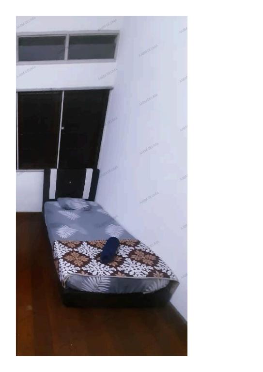 怡保AABM DELIMA HOMESTAY的铺有木地板的客房内的一张小床