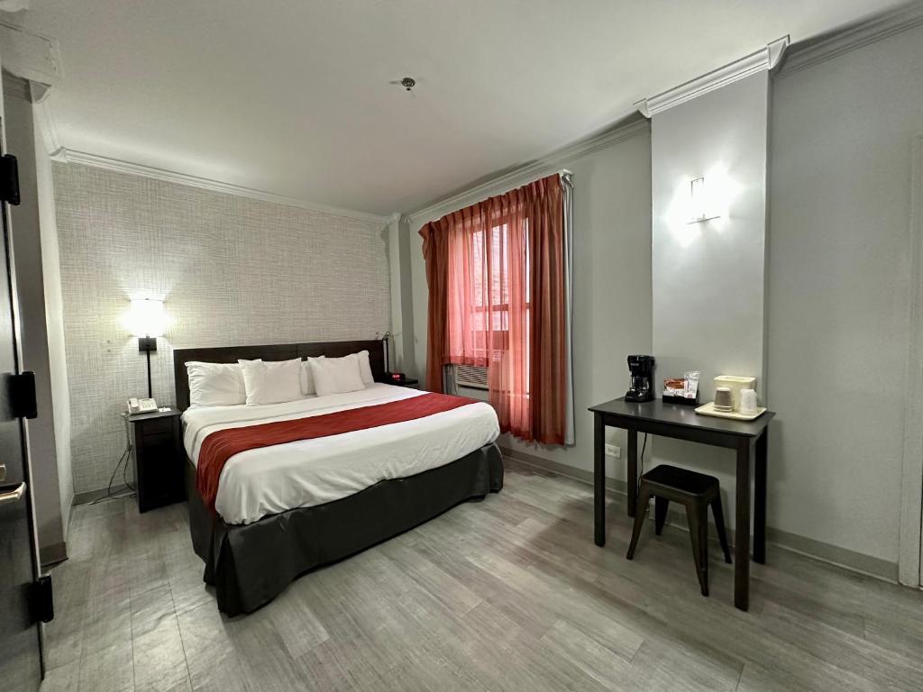 纽约纽约市遗产酒店的酒店客房设有一张大床和一张桌子。