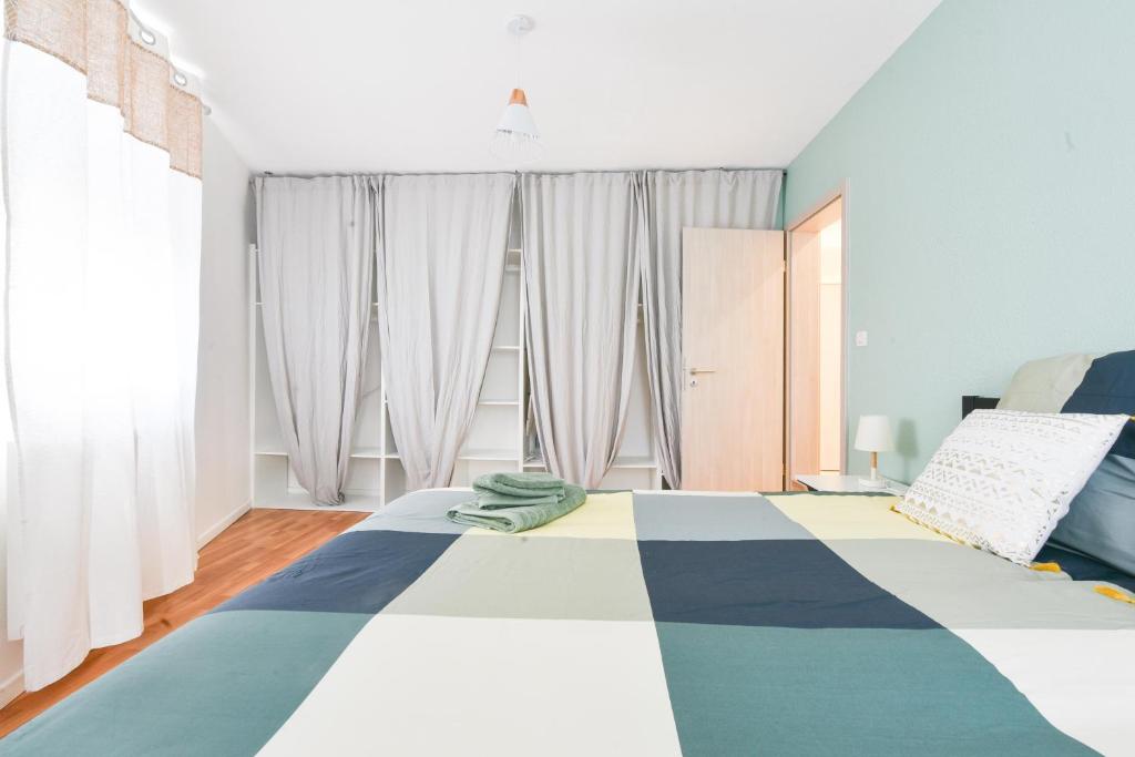米卢斯Evasion Mulhousienne的一间卧室配有一张带蓝白色毯子的床