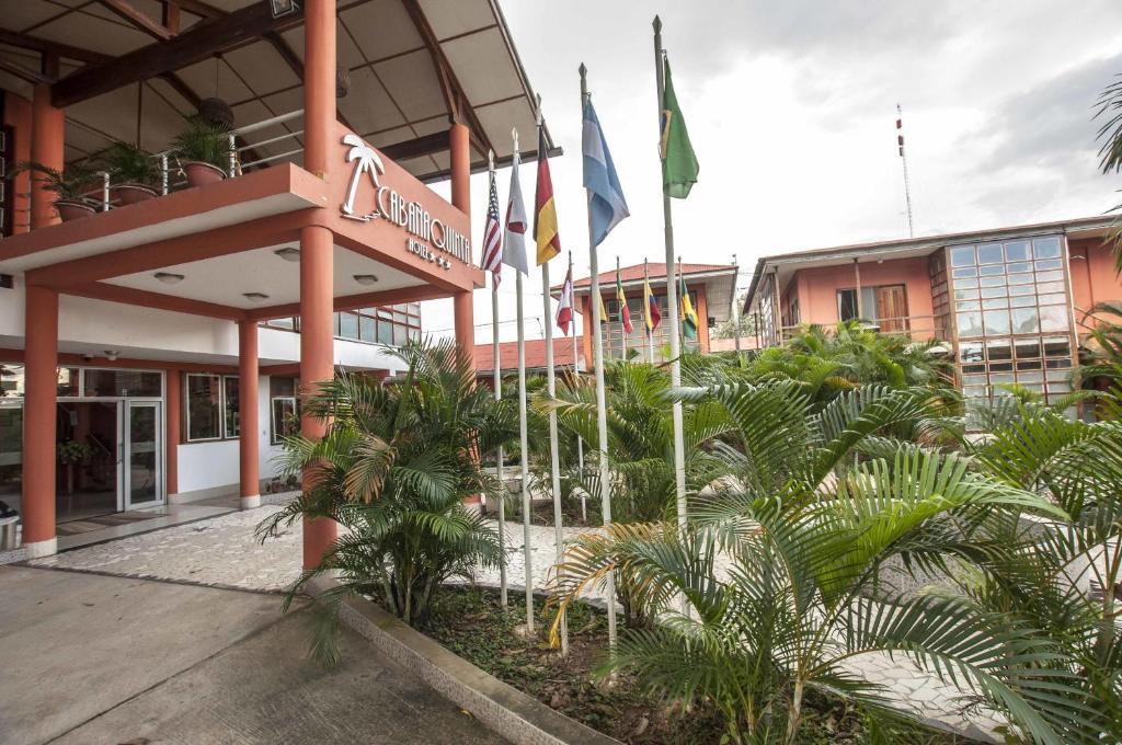 马尔多纳多港金塔酒店的前面有旗帜和棕榈树的建筑