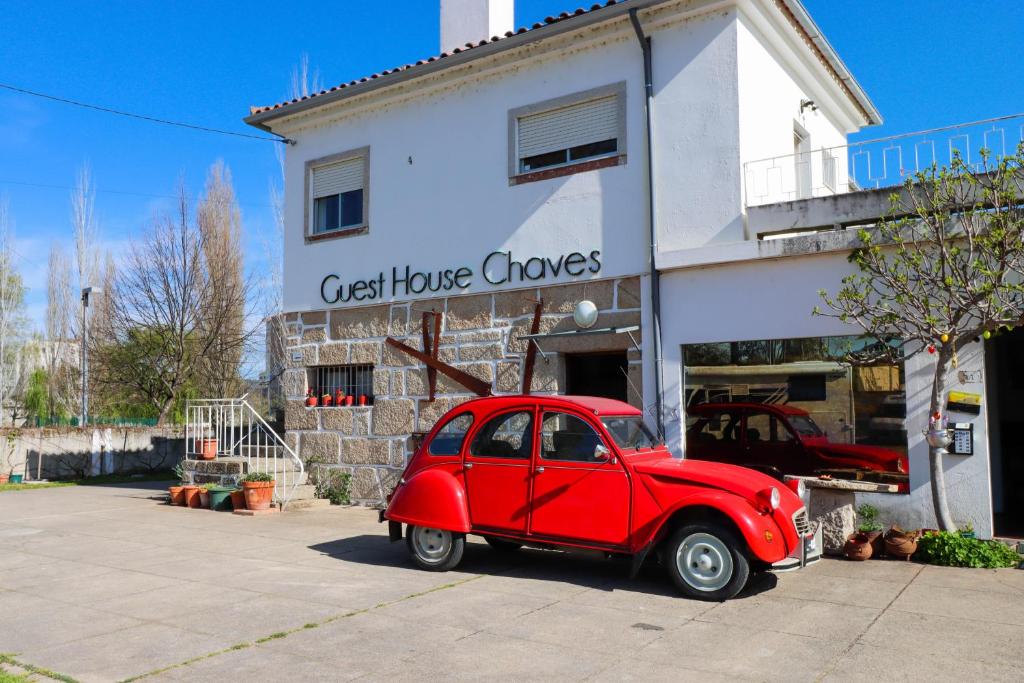查韦斯Guest House Chaves的停在房子前面的一辆老红色汽车