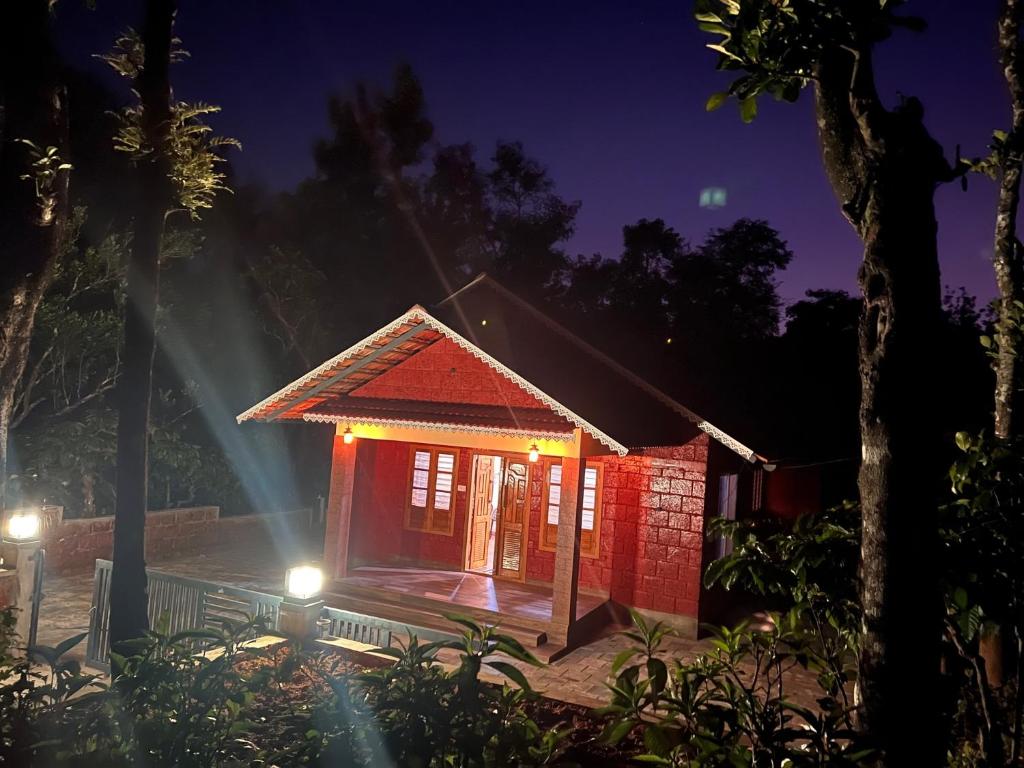 ThirunelliCoffee Bean Rest House的一间夜晚带灯光的红色小房子