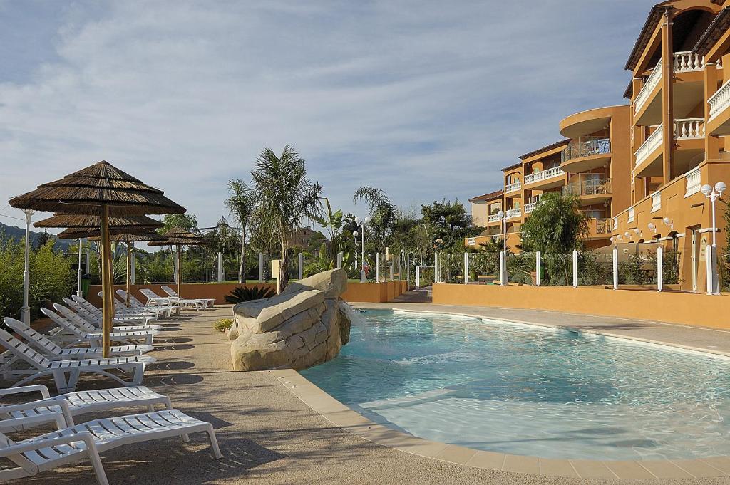 卡罗卢卡斯特雷公寓式酒店的一个带躺椅和遮阳伞的游泳池