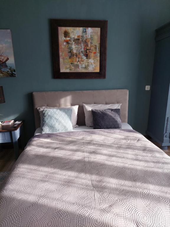 考纳斯Quiet place的卧室内的一张床铺,卧室内有蓝色的墙壁
