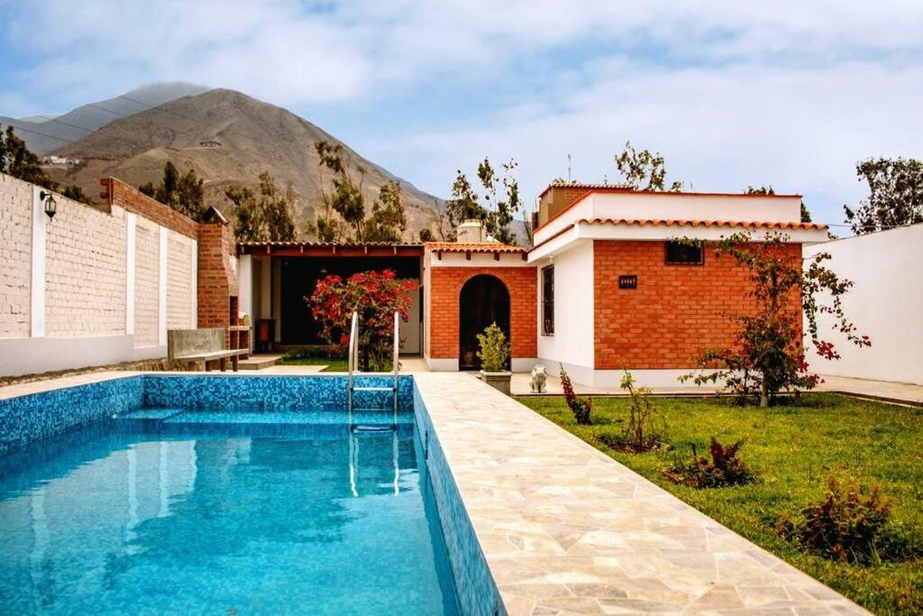 谢内吉亚区Amplia Casa de Campo con Piscina en Cieneguilla的山前的游泳池